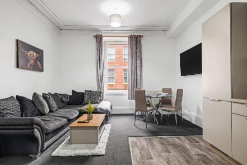 a living room with a couch and a table at Peterhead Pad - SJA Stays - Modern 2 Bed Apartment in Peterhead