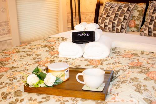 a tray of towels and cups on a bed at Timeless - Victorian Home stay in Mankato