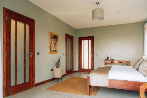 a bedroom with a bed and a table and two doors at The Scenery Residence in Arusha