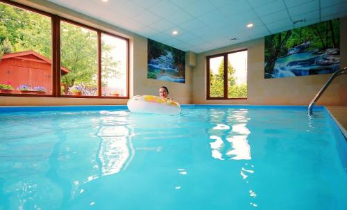 a man in a swimming pool with a frisbee at Amberia in Grzybowo