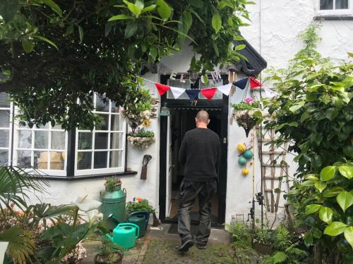 a man walking out of a house door at Harbour view cottage, clovelly in Clovelly