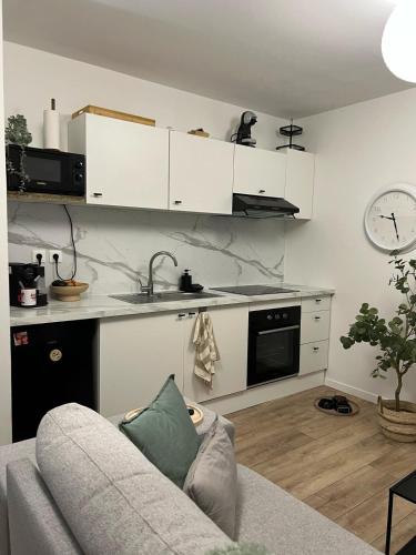 un salon avec un canapé et une cuisine dans l'établissement La belle escale proche gare climatisation, à Beauvais