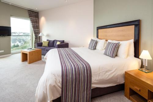 a hotel room with a large bed and a couch at Hotel de France in Saint Helier Jersey