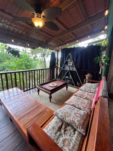 a screened in porch with a couch and a table at Gracias Madre Jungle and Ocean View Cabins in Bocas del Toro