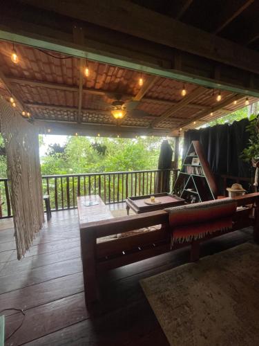 a wooden porch with a piano on a deck at Gracias Madre Jungle and Ocean View Cabins in Bocas del Toro