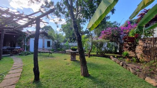 a garden with a bench and trees in a yard at Casa de Silvana - Igatu in Andaraí