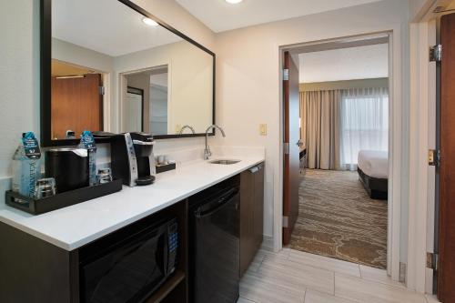 a hotel room with a sink and a mirror at Embassy Suites San Marcos Hotel Conference Center in San Marcos
