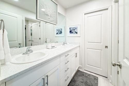 une salle de bain blanche avec un lavabo et un miroir dans l'établissement Sea Glass 312, à Gulf Shores