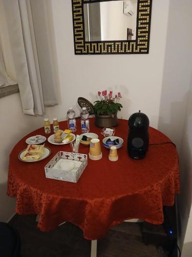 einen Tisch mit einem roten Tischtuch mit Futter drauf in der Unterkunft Il Giardino dei Desideri in Viterbo