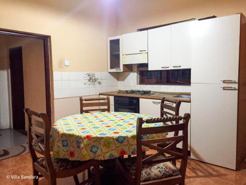 a kitchen with a table and a white refrigerator at Villa Bandara in Pannipitiya