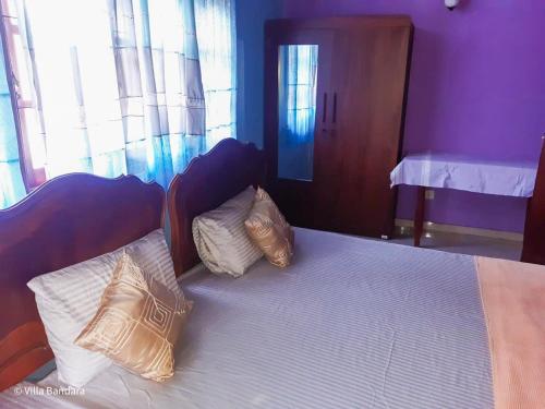 a bedroom with a bed with two pillows on it at Villa Bandara in Pannipitiya