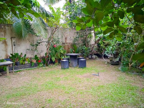 a garden with a table and two trash cans at Villa Bandara in Pannipitiya