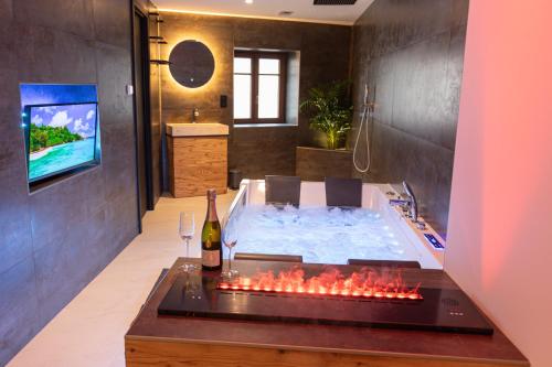 a bathroom with a tub with a bottle of wine at Haut Koeur du Château in Saint-Hippolyte