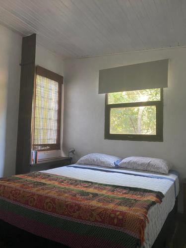 a bedroom with a large bed with a window at El Altillo in La Pedrera