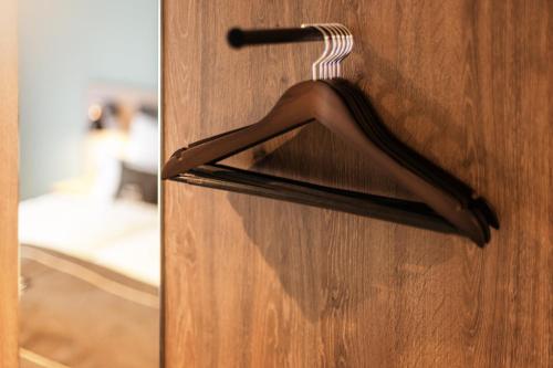a wooden door with a hanger on it at Holiday Inn - the niu, Flux Passau by IHG in Passau