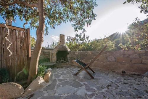 a stone patio with a bench and a stone wall at Spiti Papaya in Térsa
