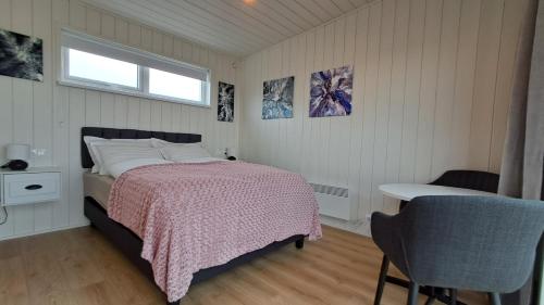 华姆斯唐吉Sauðá Guesthouse的一间卧室，里面有一张床、一张桌子和一扇窗户