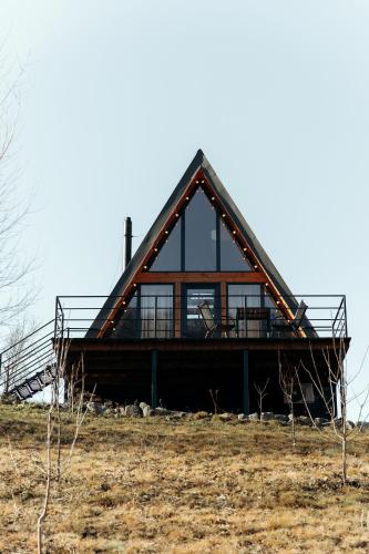 a house with a gambrel roof on top of a field at Dobrede - будиночки під лісом in Dubrynychi