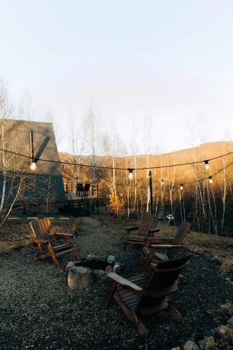 a group of wooden chairs sitting in a yard at Dobrede - будиночки під лісом in Dubrynychi