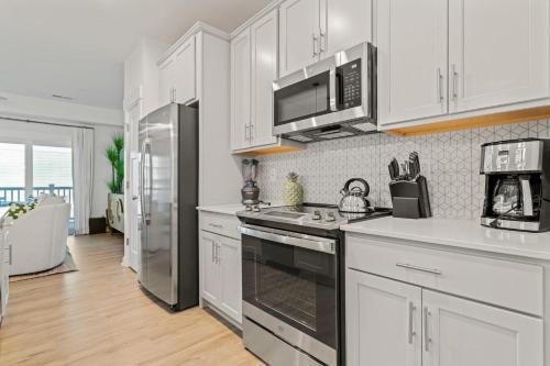 a kitchen with white cabinets and a stove top oven at Cambridge Reserve at Bermuda Bay by KEES Vacations in Kill Devil Hills
