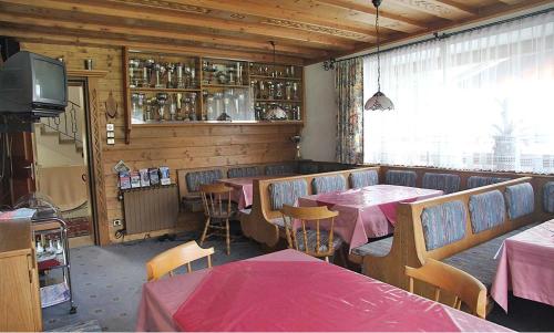 a restaurant with tables and chairs and a television at Berghaus Maria in Pettneu am Arlberg