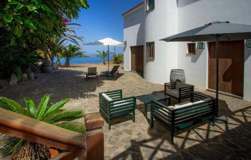 加拉奇科Haus Am Meer In Garachico的带桌椅和遮阳伞的露台