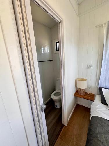 a small bathroom with a toilet and a bed at The Beach Arrawarra in Arrawarra