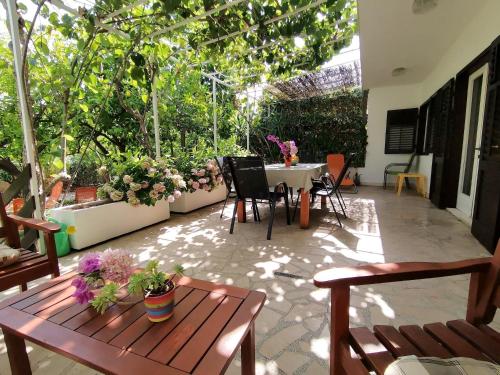 un patio con tavolo, sedie e piante di Ferienhaus Karmen Auf Zwei Ebenen Mit Garten a Orebić (Sabbioncello)