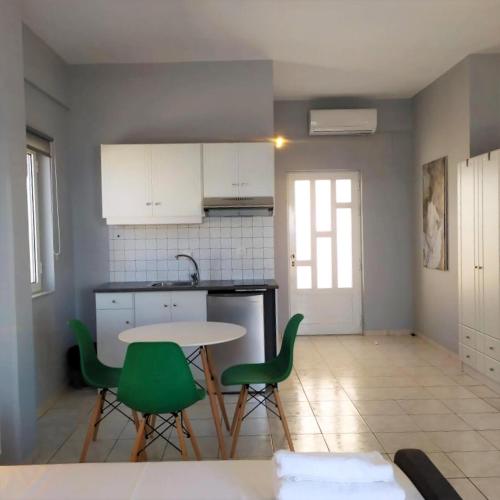 a kitchen with a table and some green chairs at Ferienwohnung In Kato Gouves Mit Gemeinschaftspool in Kato Gouves