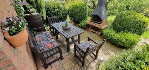 a patio with a table and chairs and a fireplace at Sonnendurchflutetes Ferienhaus Mit Wintergarten in Marienmünster