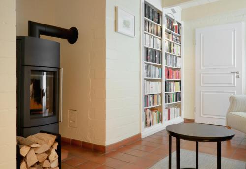 a living room with a fireplace and bookshelves at Haus Möwennest in Midlum