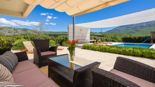 a patio with a table and chairs and a pool at Ferienhaus In Dugopolje Mit Beheiztem Pool in Dugopolje