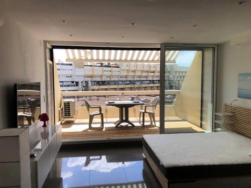 Cette chambre dispose d'une table et d'un balcon avec une table. dans l'établissement Résidence Héliopolis Bâtiment E - Studio 2 pers. HELIOPOLIS E MAE-4594, au Cap d'Agde