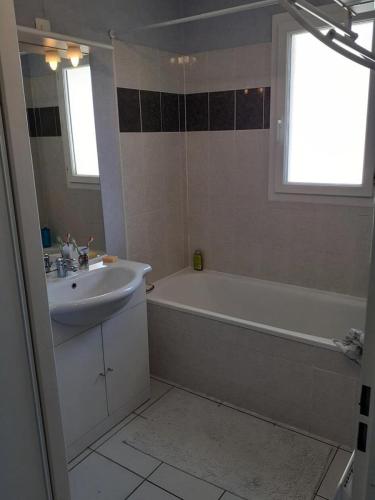 une salle de bain avec un lavabo et une baignoire et un lavabo dans l'établissement Résidence Closerie De Margot - 019 - Environnement calme pour cette maison pouvant accueillir 4 personnes MAE-4341, à Soulac-sur-Mer