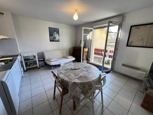 un soggiorno con tavolo e cucina di Résidence Les Vagues - 059 - Appartement idéalement situé à 50 m des plages Soulacaises MAE-4371 a Soulac-sur-Mer