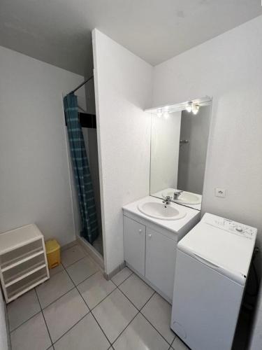 une salle de bain blanche avec un lavabo et un miroir dans l'établissement Résidence Les Vagues - 059 - Appartement idéalement situé à 50 m des plages Soulacaises MAE-4371, à Soulac-sur-Mer
