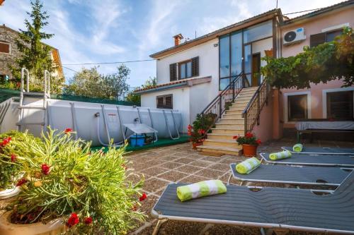 a courtyard with two benches and a house at Apartment Sankovic in Svetvinčenat