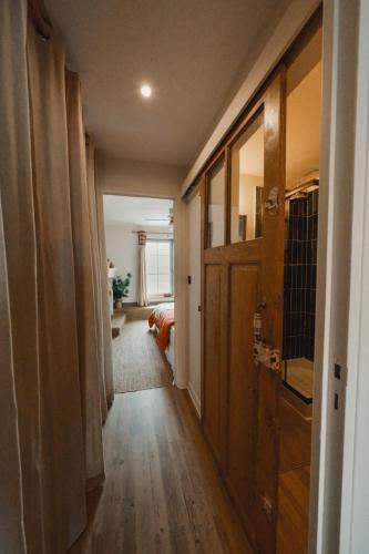 un couloir menant à un salon avec une porte dans l'établissement Le Charme - Petite Maison, à La Ferté-Bernard