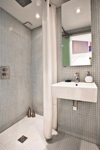 une salle de bain avec un lavabo et un miroir dans l'établissement Stylish,luxury duplex Paris city center, à Paris