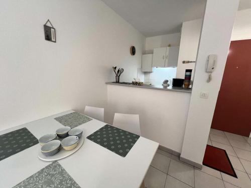 - une cuisine avec une table blanche et des bols dans l'établissement Résidence Les Goélands - 013 - Appartement à deux pas du centre ville de Soulac MAE-6171, à Soulac-sur-Mer