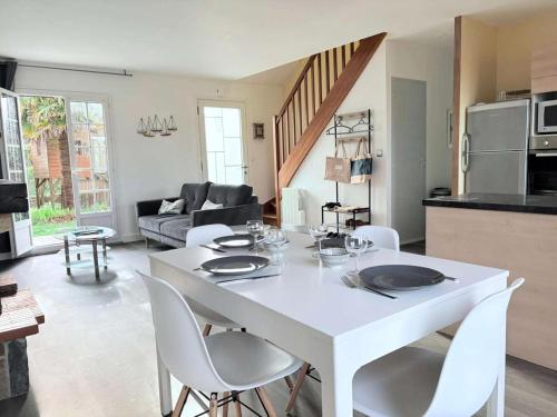 une table blanche et des chaises dans un salon dans l'établissement Résidence L98-perros Guirec - Maison avec jardin, proche de Trestraou MAE-8521, à Perros-Guirec
