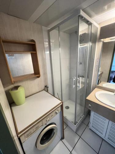 La petite salle de bains est pourvue d'une douche et d'un lave-linge. dans l'établissement Résidence Marcellus - 091 - Bel appartement en centre ville avec piscine collective MAE-4391, à Soulac-sur-Mer