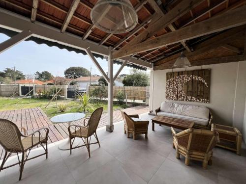 d'une terrasse avec un lit, des chaises et une table. dans l'établissement Résidence 096-soulac Sur Mer - 096 - Séjournez dans le charme de Soulac/mer : maison cosy avec jardin MAE-4441, à Soulac-sur-Mer