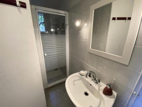 une salle de bain blanche avec un lavabo et un miroir dans l'établissement Résidence 086-soulac Sur Mer - 086 - Très belle villa Soulacaise au calme et sans vis à vis MAE-4481, à Soulac-sur-Mer