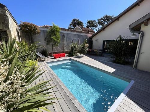 une piscine dans l'arrière-cour d'une maison dans l'établissement Résidence 023-soulac Sur Mer - 023 - Magnifique villa en duplex avec piscine en plein cœur de la station de Soulac/mer MAE-6041, à Soulac-sur-Mer