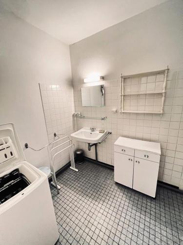La salle de bains est pourvue de carrelage blanc, d'un lavabo et d'un lavabo. dans l'établissement Résidence 062-soulac Sur Mer - 062 - Maison au calme proche des plages et des commerces MAE-6101, à Soulac-sur-Mer