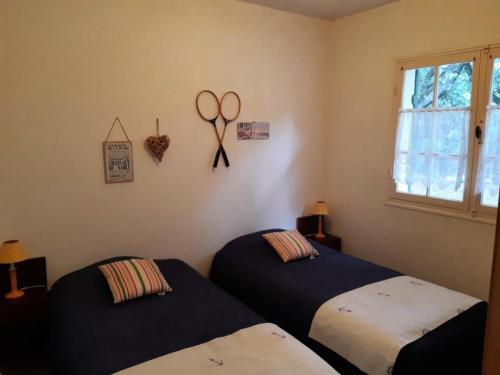 une chambre avec deux lits et une paire de ciseaux sur le mur dans l'établissement Résidence 062-soulac Sur Mer - 062 - Maison au calme proche des plages et des commerces MAE-6101, à Soulac-sur-Mer