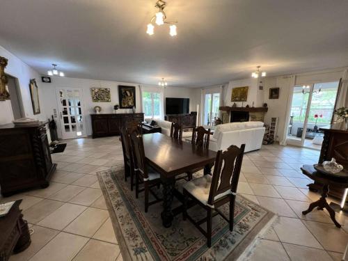 un salon avec une table et des chaises en bois dans l'établissement Résidence 104-grayan Et L Hopital - 104 - Agréable villa avec piscine dans un quartier calme MAE-6111, à Grayan-et-lʼHôpital