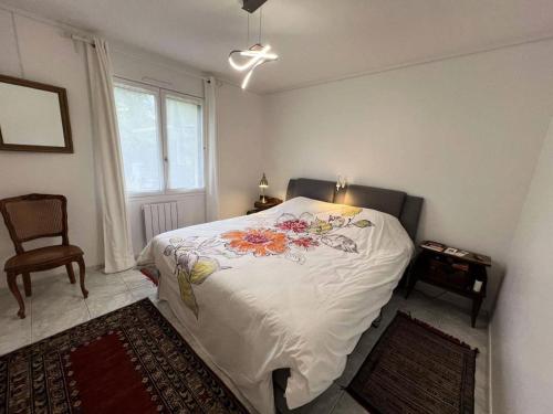 ein Schlafzimmer mit einem großen weißen Bett mit Blumen darauf in der Unterkunft Résidence 104-grayan Et L Hopital - 104 - Agréable villa avec piscine dans un quartier calme MAE-6111 in Grayan-et-lʼHôpital