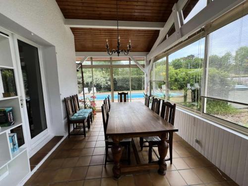 ein Esszimmer mit einem Holztisch und Stühlen in der Unterkunft Résidence 104-grayan Et L Hopital - 104 - Agréable villa avec piscine dans un quartier calme MAE-6111 in Grayan-et-lʼHôpital